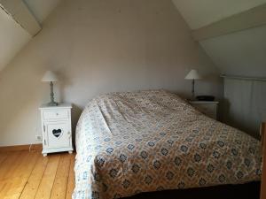 a bedroom with a bed and a white night stand at la pause campagne in Pullay