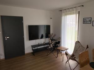 a living room with a flat screen tv and chairs at Naše Borovka in Borová Lada