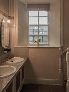 baño con 2 lavabos y ventana en Preston House, en Abbeyleix