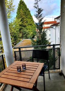 een houten tafel met twee kopjes op een balkon bij Römerpark 2 Zi-Appartement in Lindau