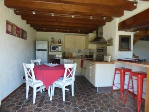 a kitchen with a red table and chairs in it at la pause campagne in Pullay