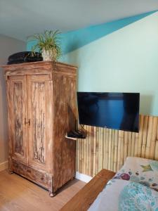 ein Schlafzimmer mit einem Holzschrank mit Pflanzen darauf in der Unterkunft Studio Pipper in Zandvoort