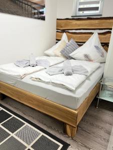 Una cama con sábanas blancas y toallas. en Ferienwohnung " Panoramablick " mit Hallenbad Berg und Seesicht, en Oberteuringen