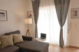 a living room with a couch and a window with a laptop at ML Central Vila Apartment in Carvoeiro