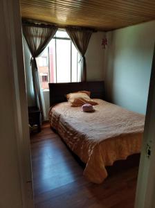 a bedroom with a large bed with a window at Mirador del parque in Bogotá