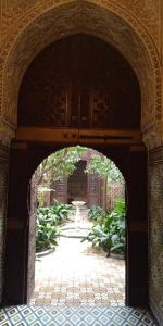 an archway in a building with a courtyard with plants at Riad Dar Zaida in Marrakech