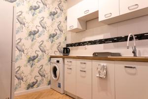 a kitchen with a washer and dryer in a room at ClickTheFlat Aleje Jerozolimskie Center Apart Rooms in Warsaw