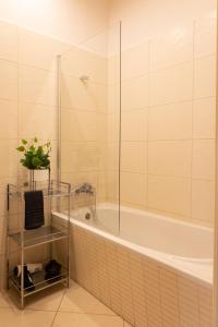 a bathroom with a tub and a plant on a shelf at ClickTheFlat Aleje Jerozolimskie Center Apart Rooms in Warsaw