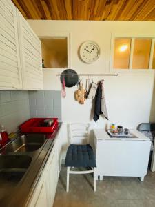 una cocina con fregadero y un reloj en la pared en Studio COSY avec parking et wifi gratuit, en Bagnoles de l'Orne