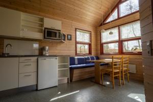 a kitchen and dining room with a table and chairs at Hedelandets Camping in Sevel