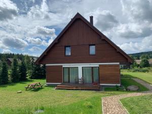 a large wooden house with a picnic table in front of it at Naše Borovka in Borová Lada