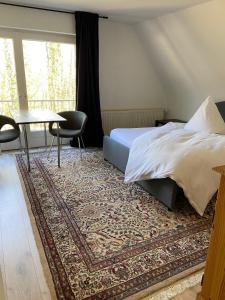 a bedroom with a bed and a table and a rug at Königlicher Aufenthalt inmitten der Natur in Hürth