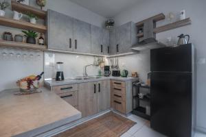 a kitchen with a black refrigerator and wooden cabinets at Inconceptual apartment in Paradeísion