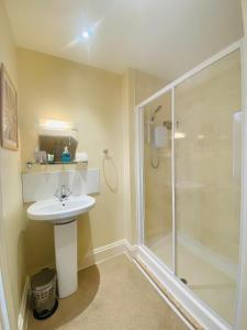a bathroom with a sink and a shower at Coastal Waters (Hotel Barton) in Torquay +31 photos