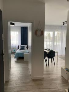 sypialnia z łóżkiem i pokój ze stołem w obiekcie Apartament BLUE Rewal w Rewalu