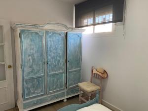 a blue cabinet in a room with a chair at Apartamento Los Escullos in Los Escullos