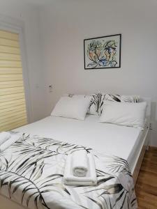 a white bed with two towels on top of it at Cosmopolit Apartments in Ohrid