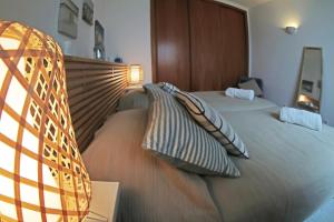 1 dormitorio con 2 camas y almohadas en ML Central Vila Apartment en Carvoeiro
