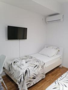 een slaapkamer met een bed en een tv aan de muur bij Cosmopolit Apartments in Ohrid