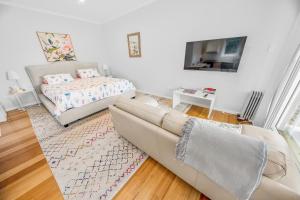 a living room with a couch and a bed at Cromwell Lite in Cooma