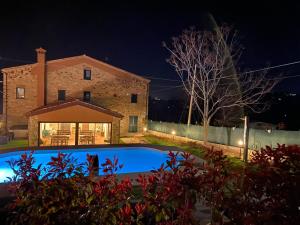 a house and a swimming pool at night at Casa Giogano in San Leo