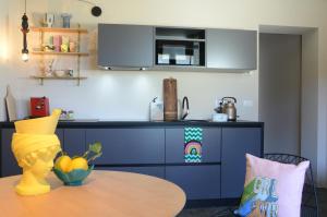 a kitchen with a table and a blue cabinet at Picobello Lago in Mandello del Lario