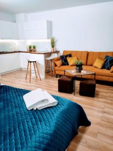 salon z łóżkiem i kanapą w obiekcie Apartamenty Suerte w Darłówku