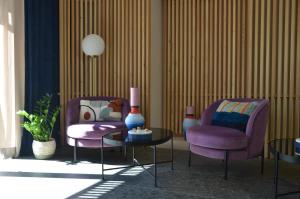 two purple chairs and a table in a room at Picobello Lago in Mandello del Lario