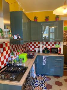 a kitchen with blue cabinets and red and white tiles at Maria Vittoria House in Turin