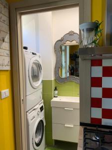 a bathroom with a washing machine and a mirror at Maria Vittoria House in Turin