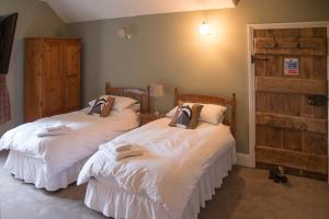 dos camas sentadas una al lado de la otra en un dormitorio en Lower House B&B Adforton, en Leintwardine