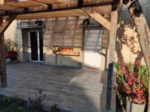 un patio al aire libre con pérgola de madera en Maison au calme dans un petit hameau, en Verdun-sur-Garonne