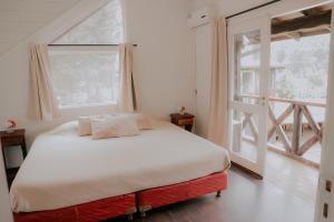 a bedroom with a bed and a large window at INDÓMITO HOSTEL in San Carlos de Bariloche