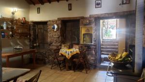 a dining room with a table and a stone wall at Pousada Encanto da Roça in Mucugê
