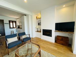 a living room with a fireplace and a tv at La Buganvilla in Zahara de la Sierra