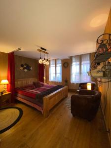 een slaapkamer met een bed, een bank en een stoel bij Au Bois Normand in Honfleur