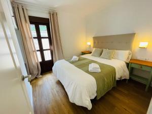 a bedroom with a large bed and a window at La Buganvilla in Zahara de la Sierra