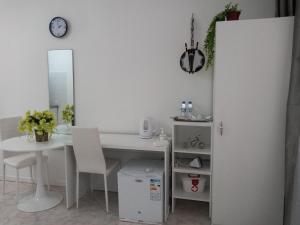 a room with a white desk and a table and a mirror at Ana Place in Praia