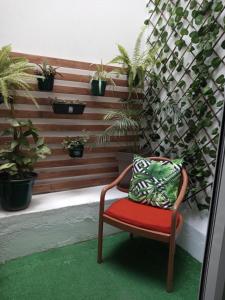 a chair with a pillow on a patio with plants at Ana Place in Praia