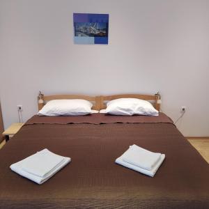 a bed with two white towels on top of it at Peter&Zana Apartments in Stari Grad