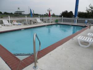 ein großer Pool mit Stühlen und einem Zaun in der Unterkunft Patti's Inn and Suites in Grand Rivers