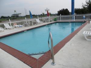 a large swimming pool with white fences and chairs at Patti's Inn and Suites in Grand Rivers +7 photos