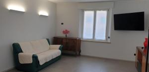 een woonkamer met een stoel en een televisie bij Appartamento ROSY in Peschiera del Garda