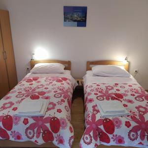 dos camas sentadas una al lado de la otra en una habitación en Peter&Zana Apartments, en Stari Grad