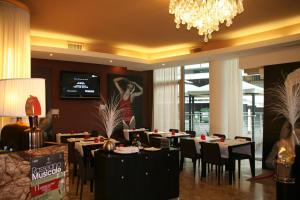 jadalnia ze stołami i krzesłami oraz żyrandolem w obiekcie Hotel Kristall w mieście San Donà di Piave