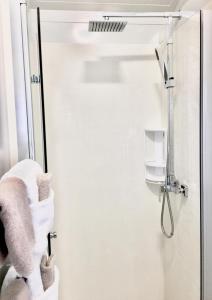 a bathroom with a shower with white towels on the wall at Almond Court Motel in Alexandra