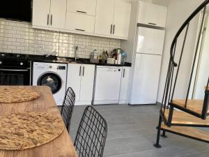 a kitchen with white appliances and a table and chairs at Villa Eliz in Dalaman