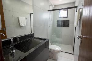a bathroom with a shower and a sink and a toilet at Pousada Terra do Vento in São Miguel do Gostoso