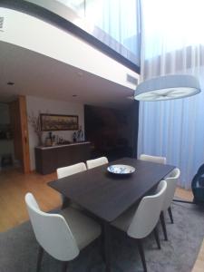 a dining room with a black table and white chairs at Ocean Village 10 in Grândola