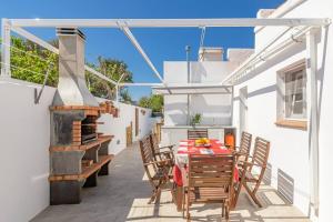 a patio with a table and chairs and a fireplace at Villa Mica in Son Carrio